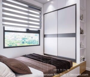 Phòng ngủ căn hộ Opal Boulevard với giường gỗ cạnh cửa sổ lớn.
